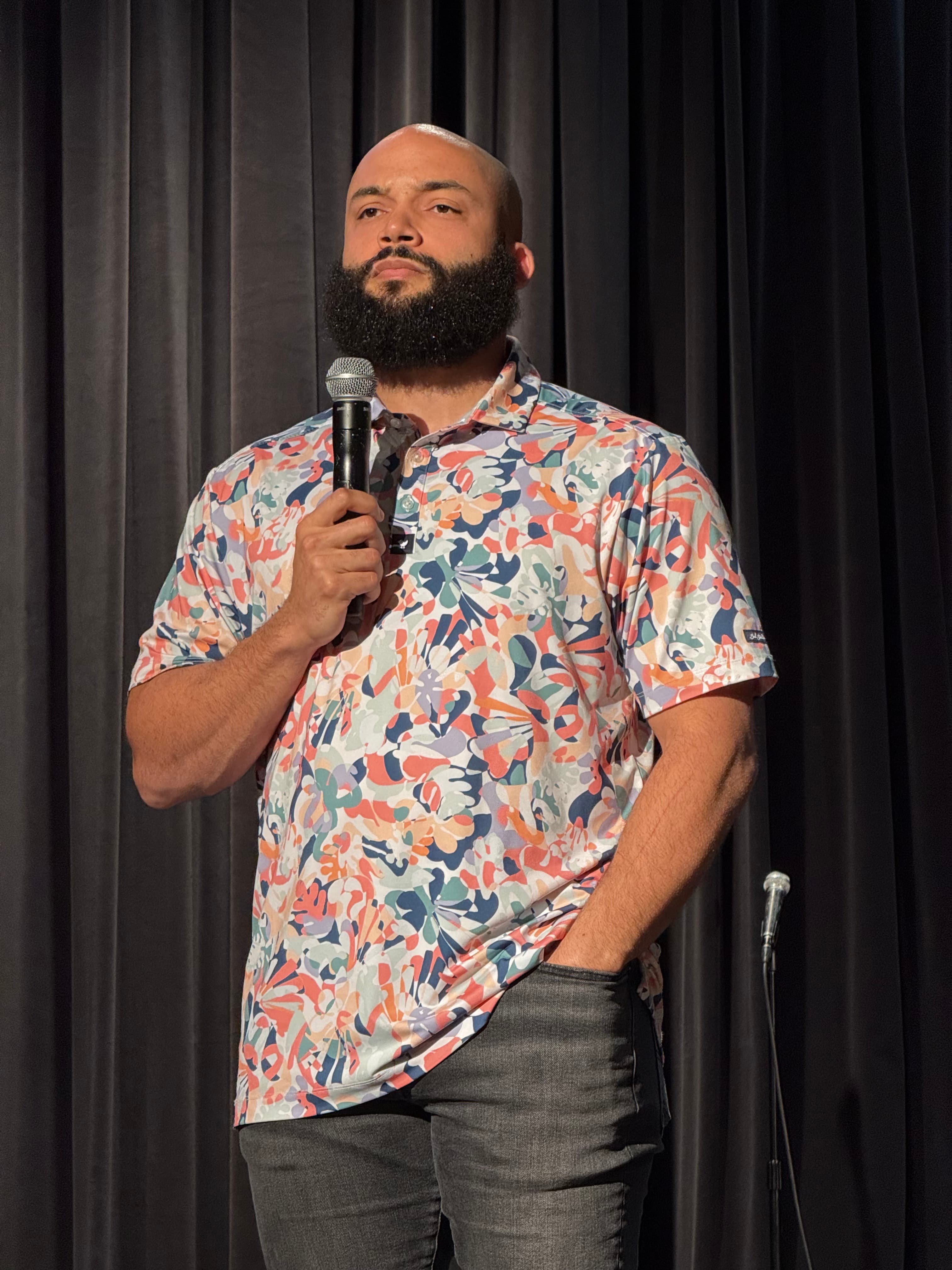 Blake M. Jones close-up while teaching, holding a wireless microphone on stage